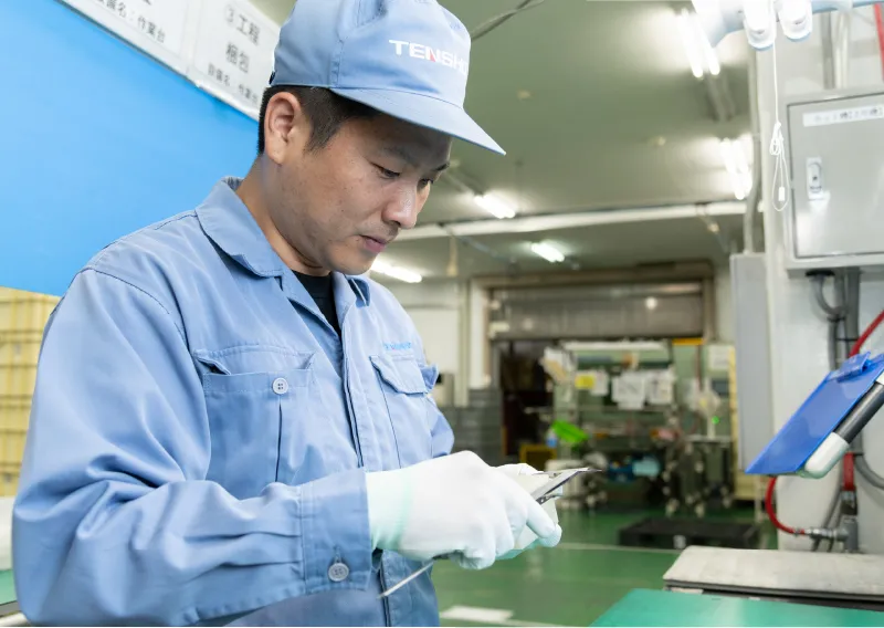 工場内で手袋を着用し、製品や部品を確認するR.Mさん