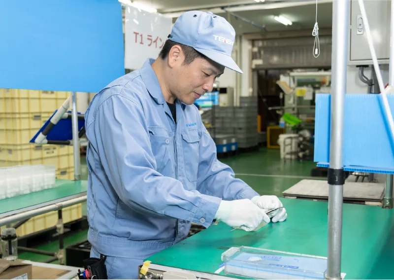 工場内で手袋を着用し、製品や部品を確認するR.Mさん