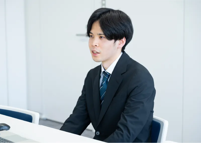 デスクで前を向く管理本部 経理部のI.Sさん
