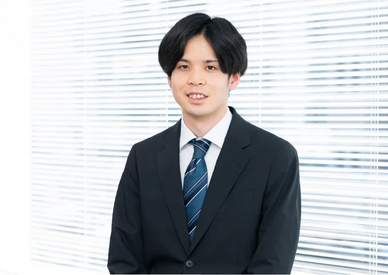 スーツ姿で微笑む管理本部 経理部のI.Sさん