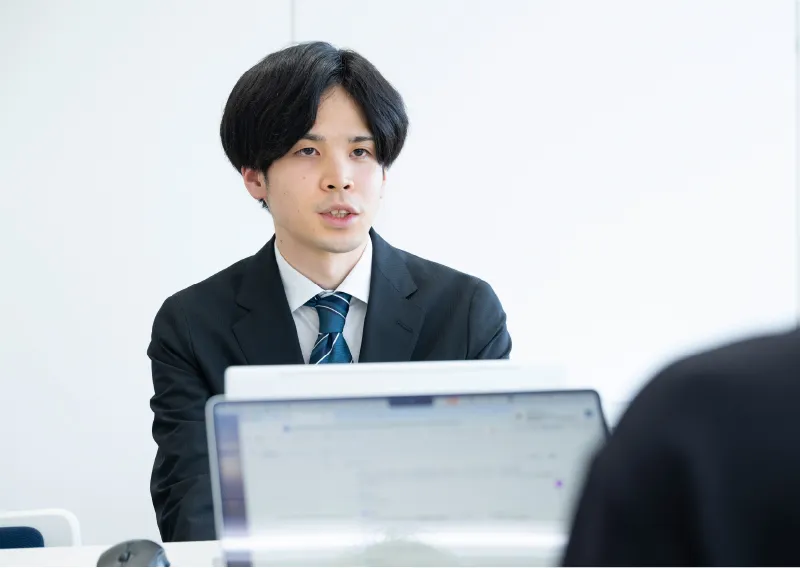 デスクでパソコンや書類を確認しながら業務を行う管理本部 経理部のI.Sさん
