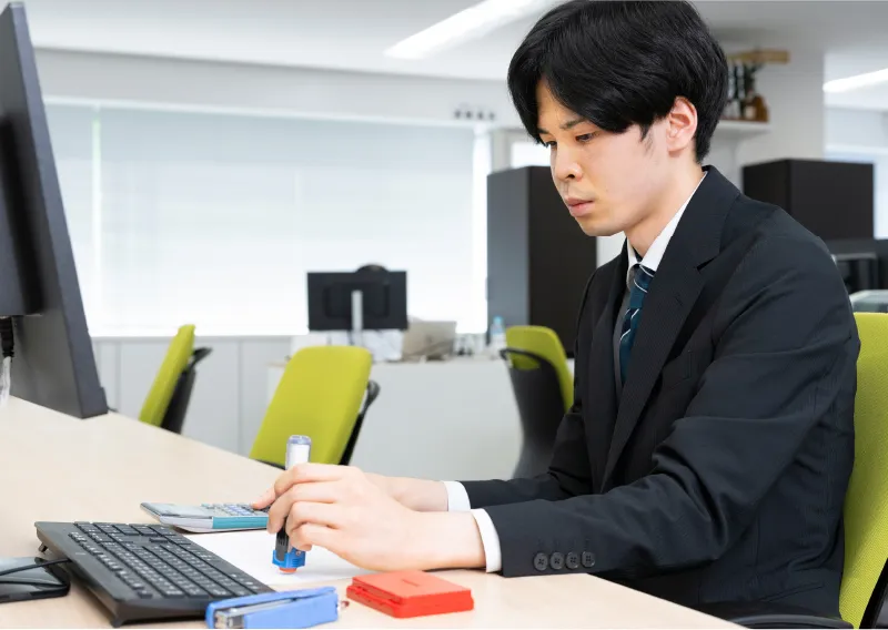 デスクでパソコン作業に取り組む管理本部 経理部のI.Sさん