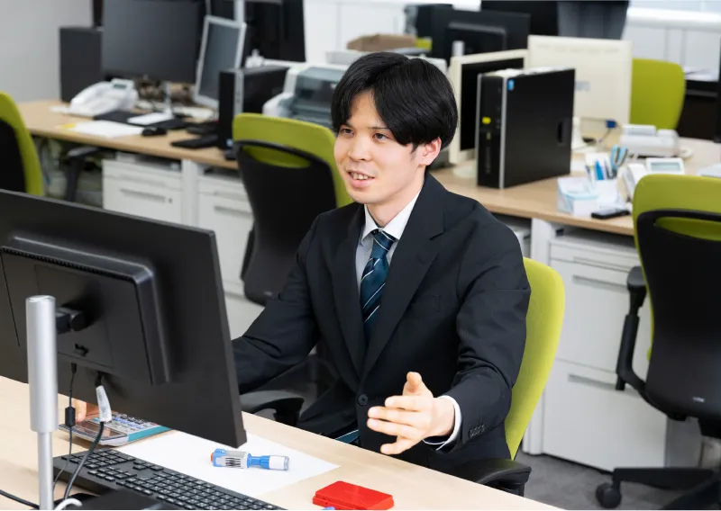 デスクでパソコンに向かい笑顔で話す管理本部 経理部のI.Sさん
