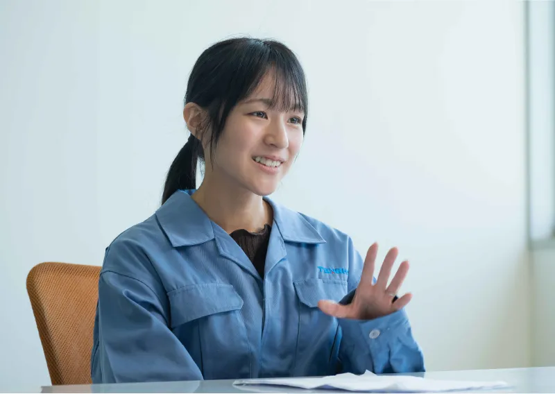 青い作業服を身にまいき、身振り手振りを交えて笑顔で話すM.Oさん