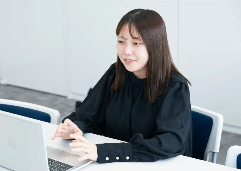 デスクでパソコンに向かい笑顔で話す品質保証部／環境管理部のN.Hさん
