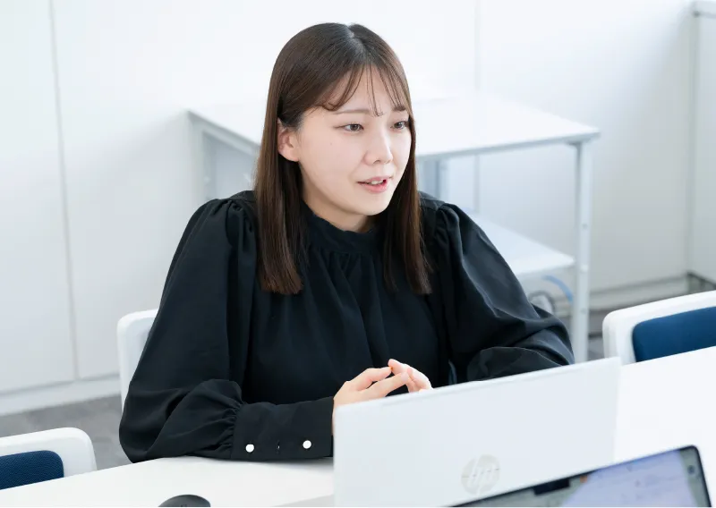 デスクでパソコンに向かい笑顔で話す品質保証部／環境管理部のN.Hさん