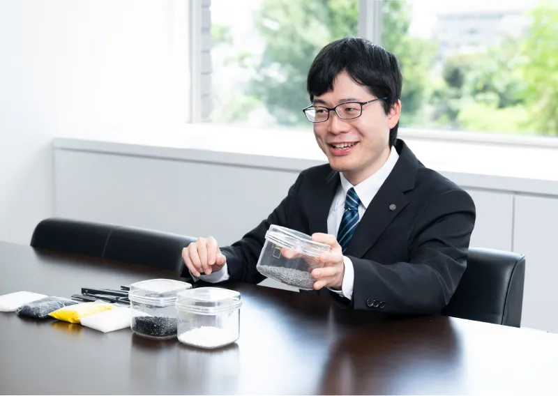 材料サンプルを手に笑顔を見せる管理本部 購買部のS.Tさん