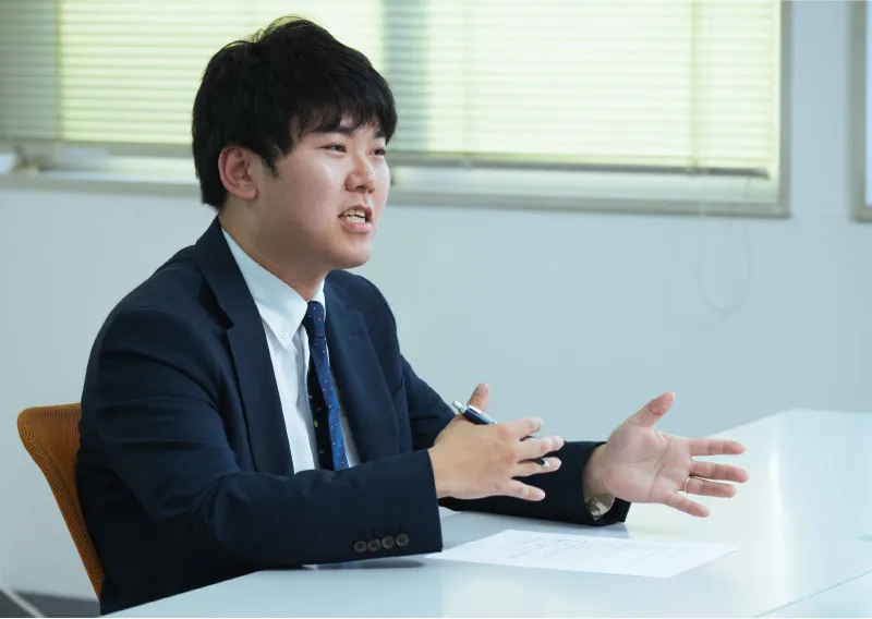 スーツ姿で身振り手振りを交えて話す三重工場 東海近畿営業部のT.Fさん