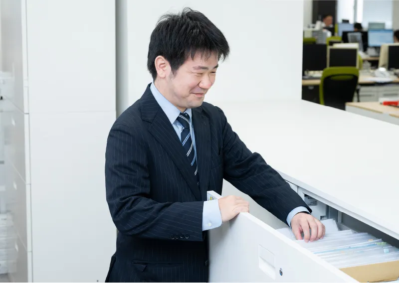 スーツ姿で笑顔を見せる総務人事部のT.Hさん