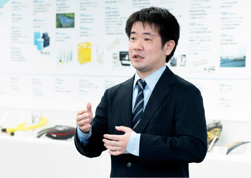 スーツ姿で身振り手振りを交えて話す総務人事部のT.Hさん