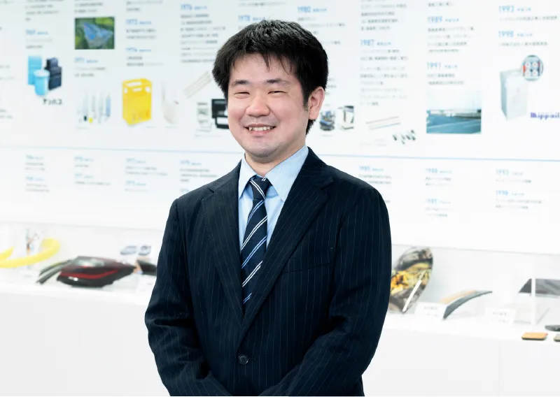 スーツ姿で笑顔を見せる総務人事部のT.Hさん