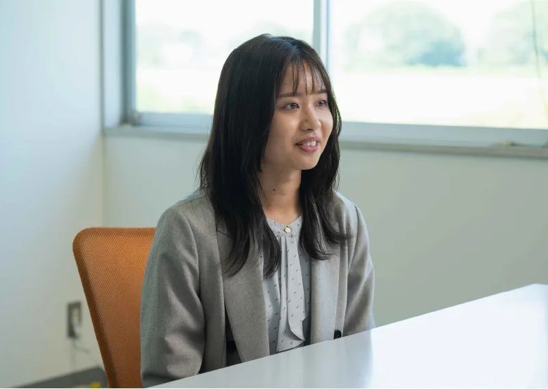 オフィスで横を向き、穏やかな表情で話すスーツ姿のU.Oさん