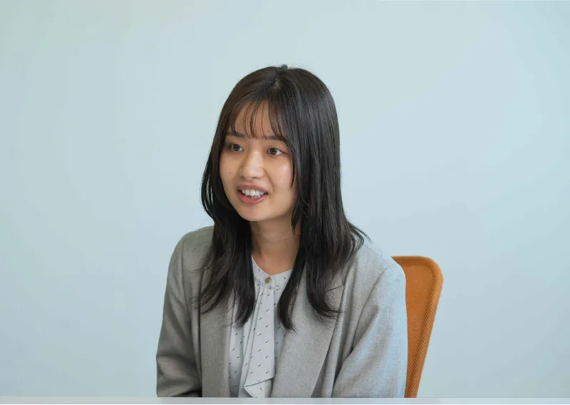 デスクに座り、柔らかな表情で話すU.Oさん