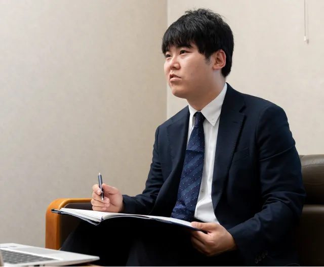 スーツ姿でタブレットを手にする営業職の社員